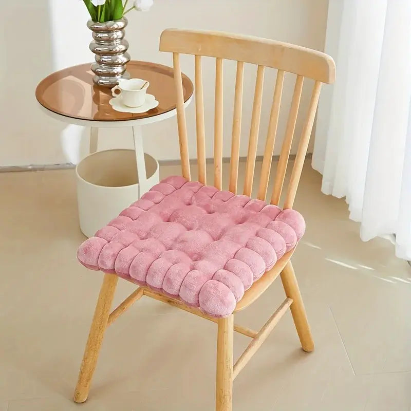 Large biscuit-shaped plush chair seat pad, pink cushion on a wooden chair