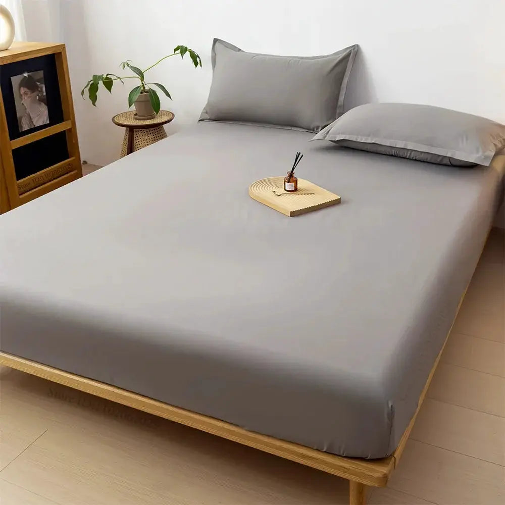 Simples Market gray waterproof mattress protector fitted sheet on a wooden platform bed with matching gray pillowcases.