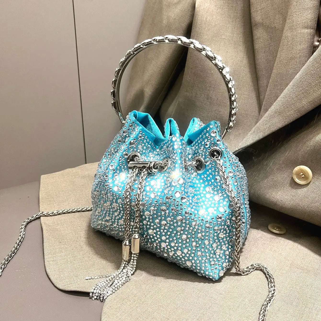 Blue rhinestone evening clutch with silver chain strap and round jewel-encrusted handle