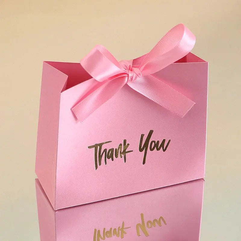 Pink gift bag with gold Thank You text and pink satin bow.