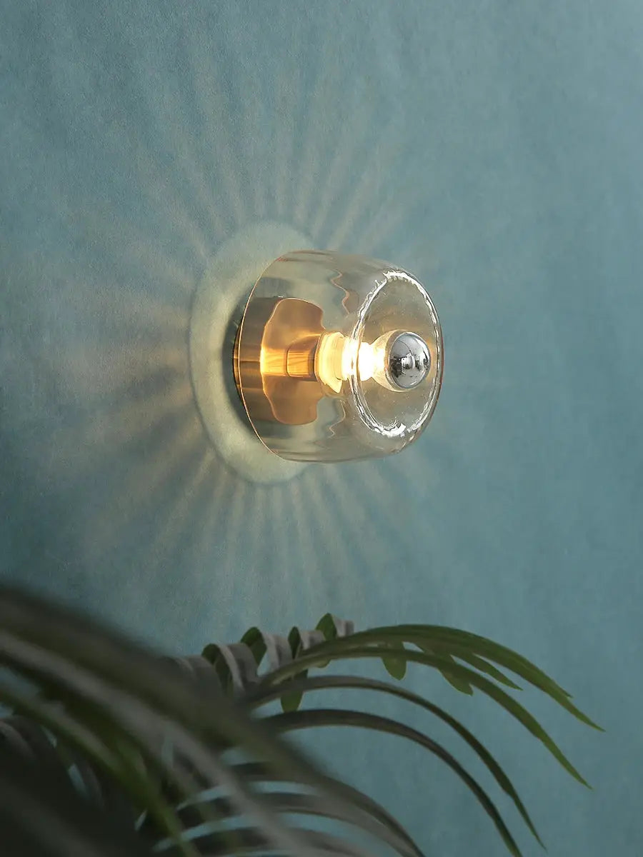LED Bauhaus glass wall lamp by Simples Market; clear glass globe shade with warm LED on brass base