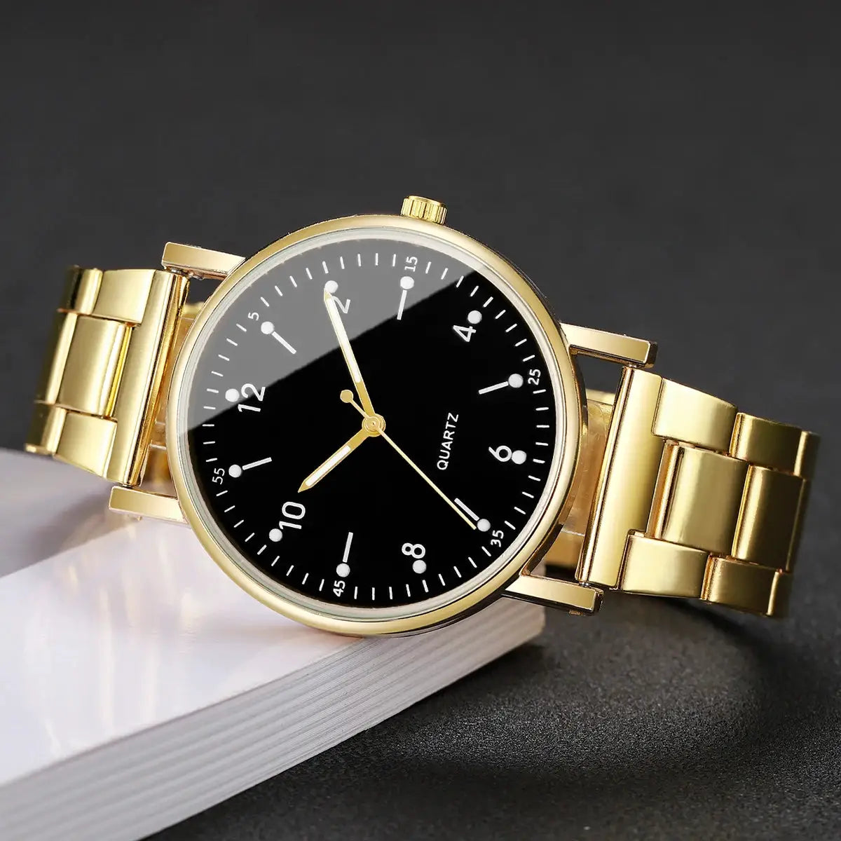 Gold-tone women's quartz wristwatch with black Arabic numeral dial and metal bracelet