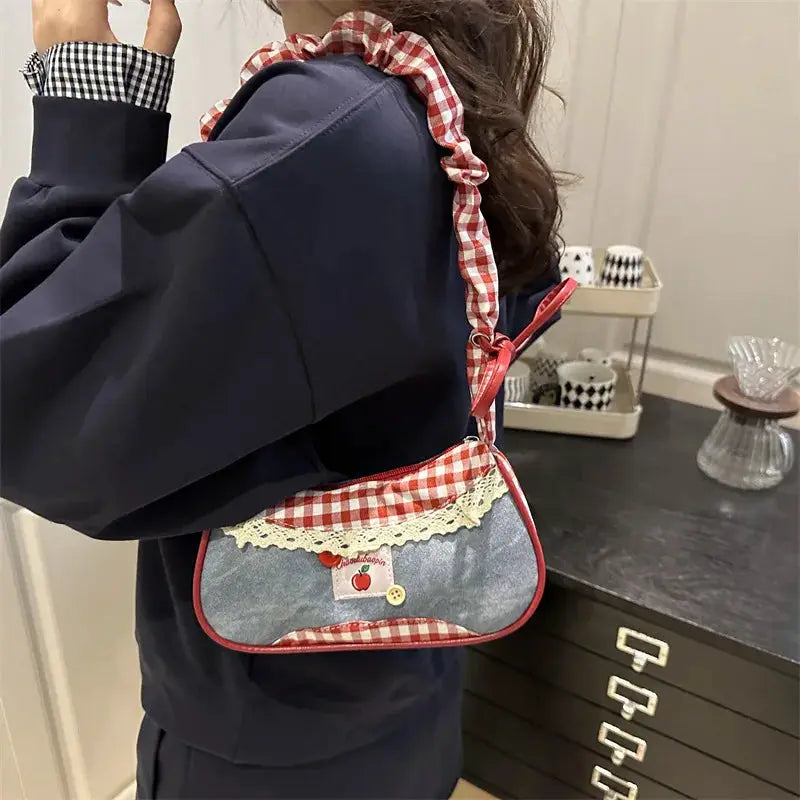 Hand-held bag by Simples Market; navy denim-style purse with red gingham strap, red piping, and lace trim