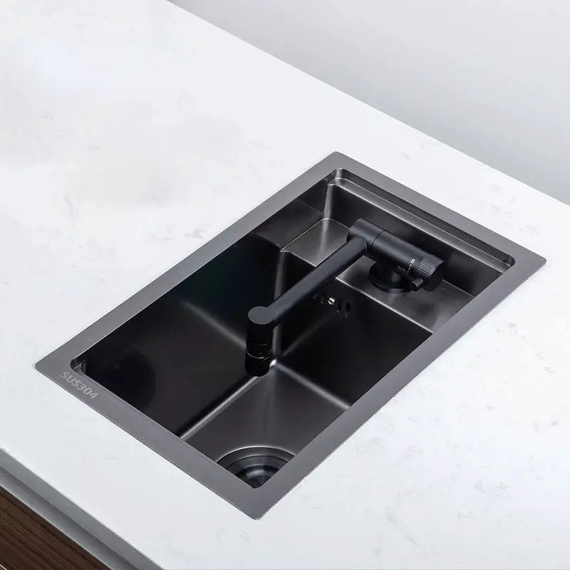 Black stainless steel kitchen sink with a single bowl and matte black faucet by Simples Market