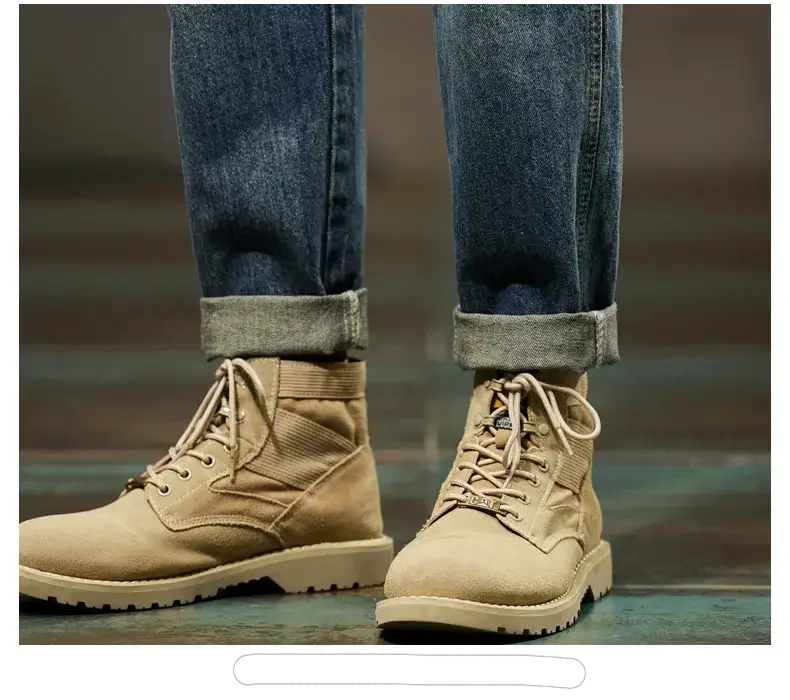 Men's beige suede hiking boots with laces and chunky soles, paired with rolled blue denim jeans