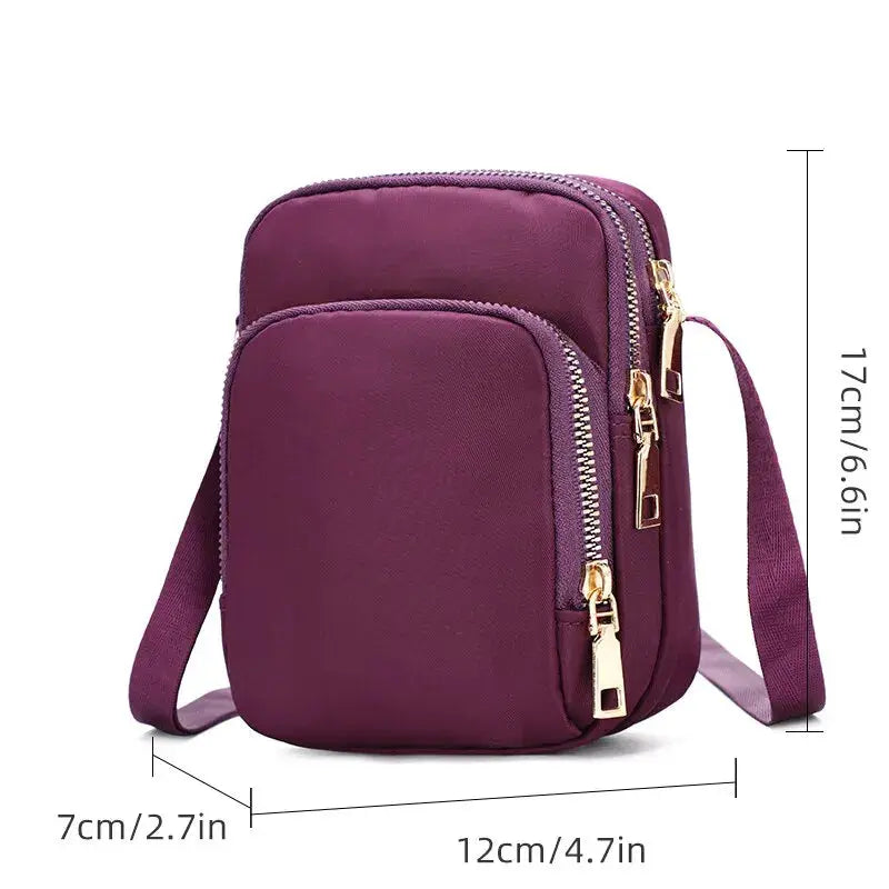 Women's waterproof crossbody bag by Simples Market in purple with phone pocket and dual zipper pockets