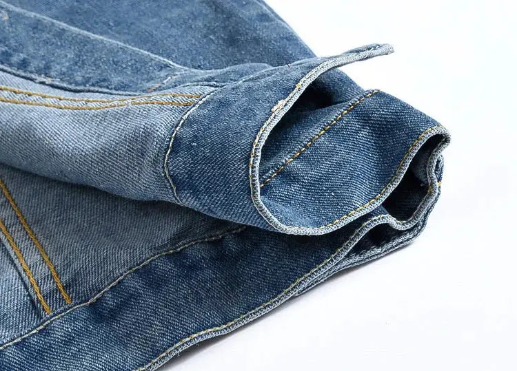 Denim jeans fabric swatch in blue with yellow topstitching, folded edges.