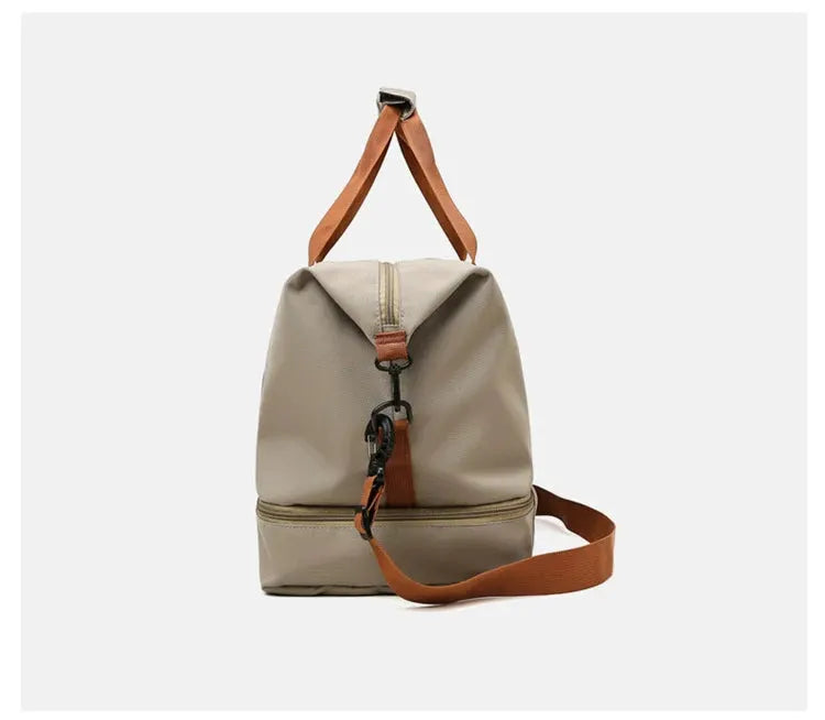 Travel gym bag, beige compact duffle with brown shoulder strap and top handle.