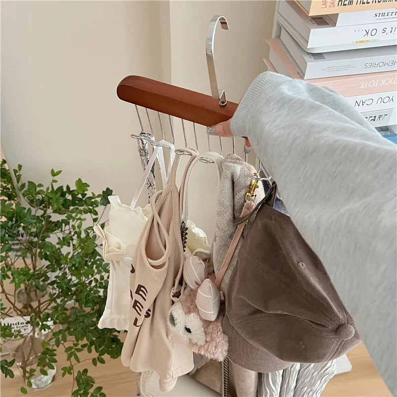 Multi-functional belt hanger clothes organizer with wooden top and silver hooks, holding garments