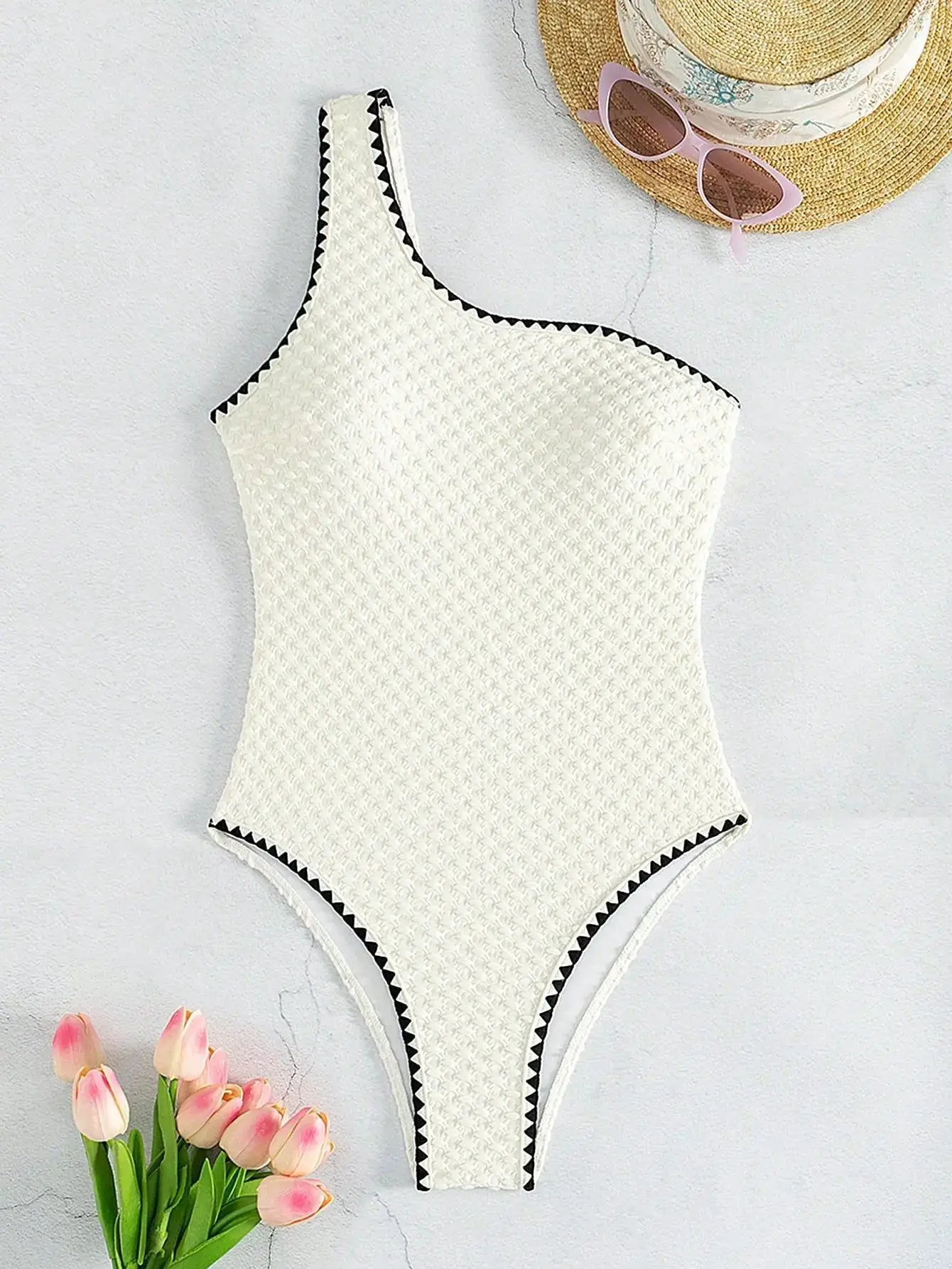 White textured one-shoulder swimsuit with black zigzag trim