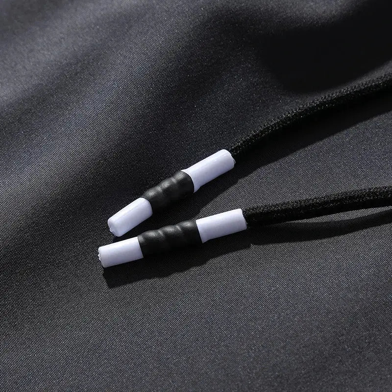 Breathable men's jogger pants with elastic waist; black fabric and white-tipped drawstrings.