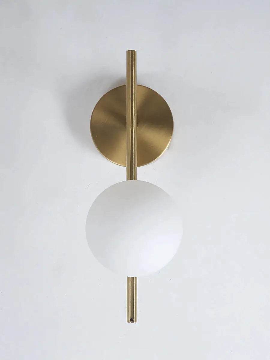 Gold brass LED wall sconce with milky glass round globe and vertical rod