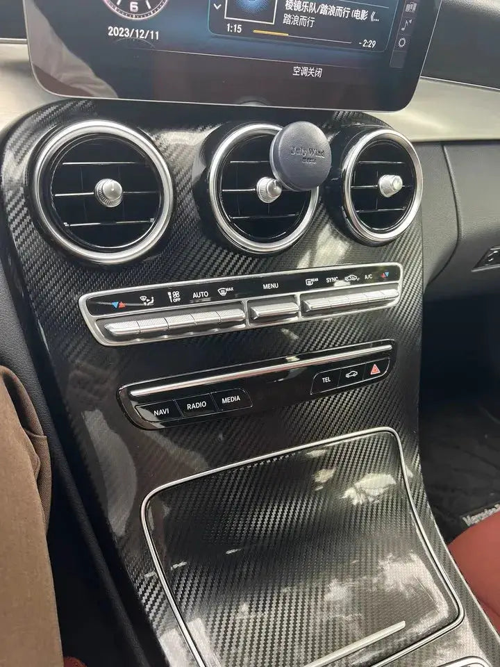 Black carbon fiber vinyl car wrap film on a car center console with round air vents