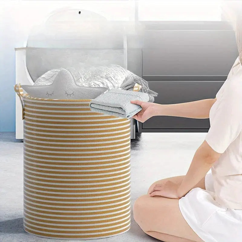 Foldable striped laundry basket in beige and white with handles; collapsible storage organizer for bathroom or bedroom.