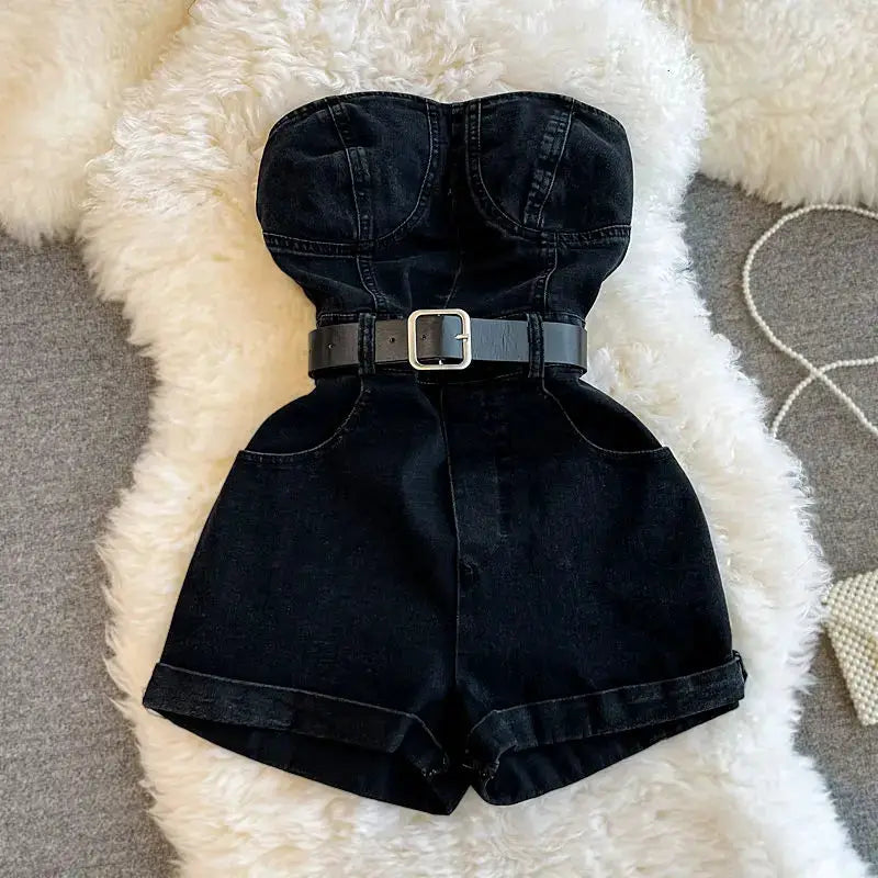Simples Market black denim romper jumpsuit, strapless off-shoulder bodice with belt and wide-leg shorts.