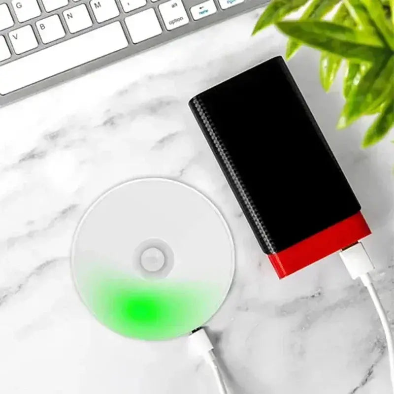 Motion sensor USB-rechargeable night light with LED disc, white with green glow, for kitchen, hallway or closet.