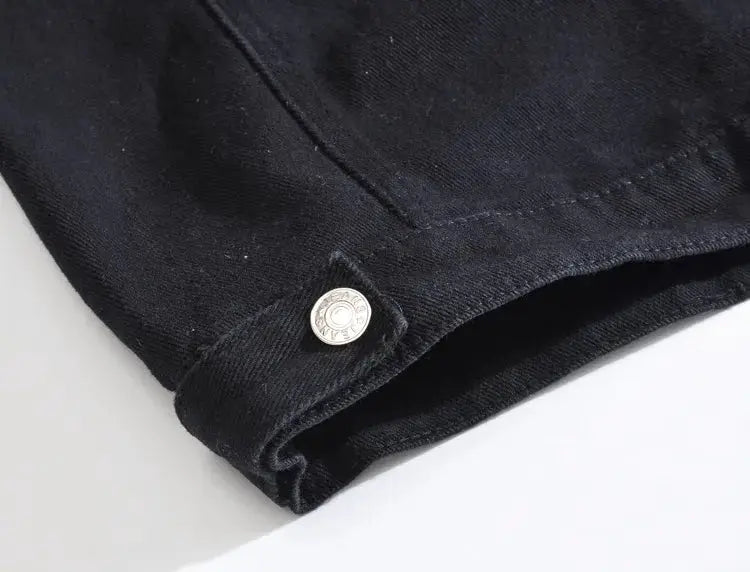 Black denim jacket sleeve with metal snap button detail closeup