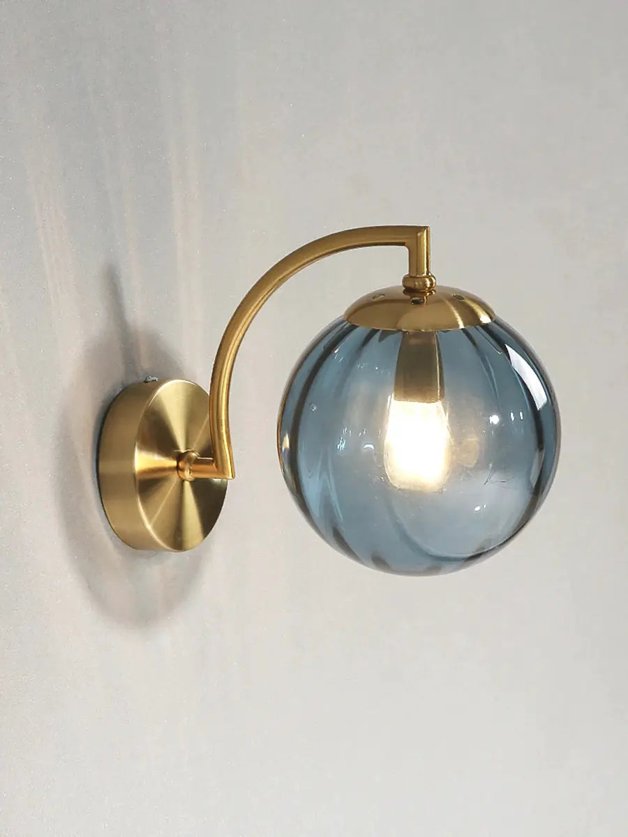 Gold brass curved wall lamp with blue glass globe shade, LED bedside sconce.