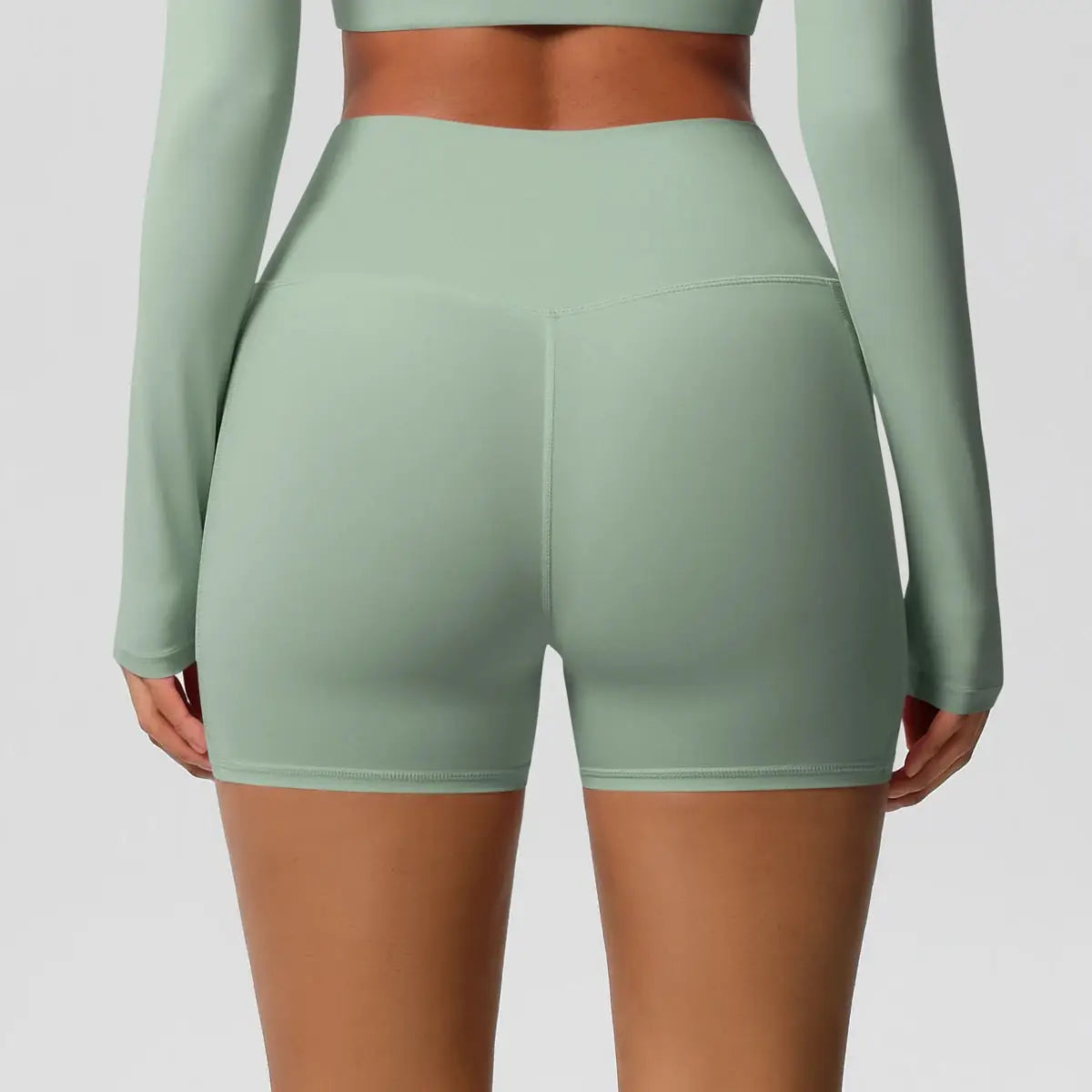 Women's mint green high-waisted athletic shorts with smooth compression fabric (back view)