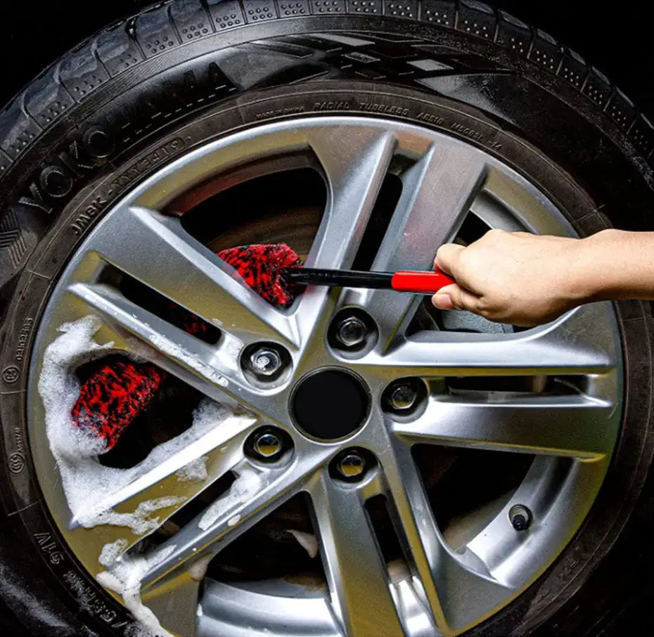 SEAMETAL bendable car wheel detailing brush by Simples Market with red-and-black handle cleaning a silver alloy wheel rim