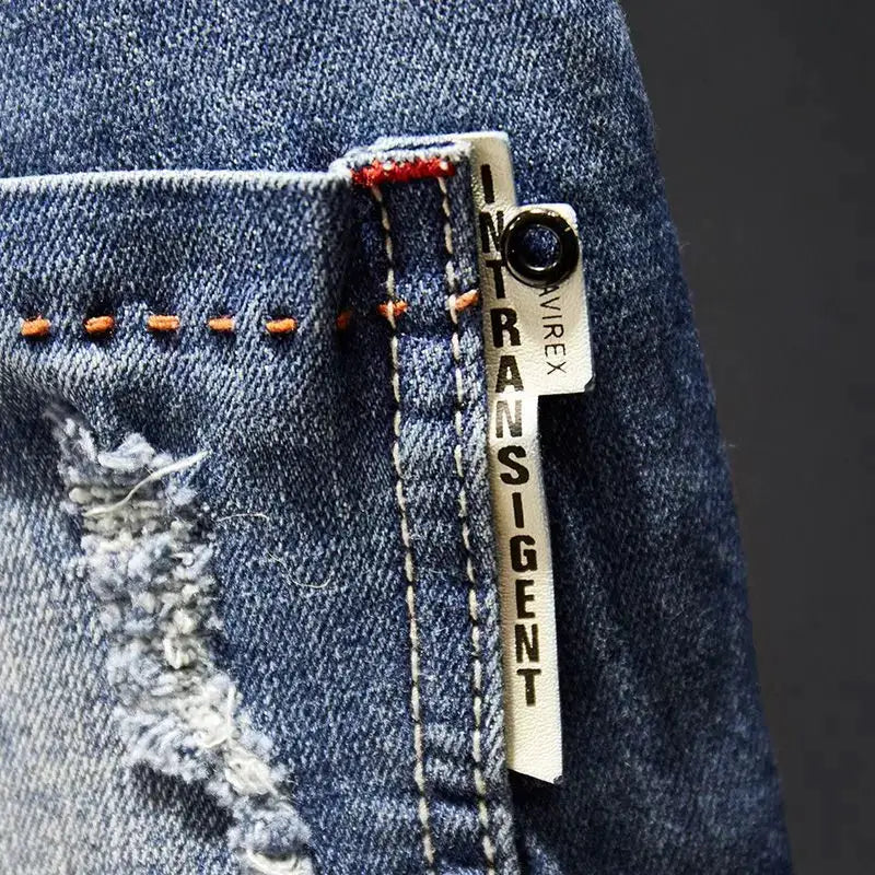 Men's blue distressed denim jeans with white Transigent tag