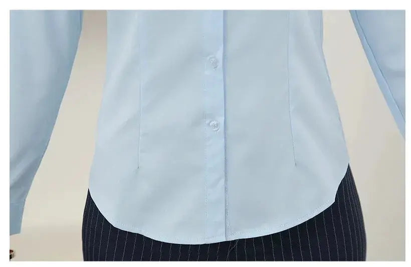 Women's light blue button-down blouse with long sleeves and curved hem