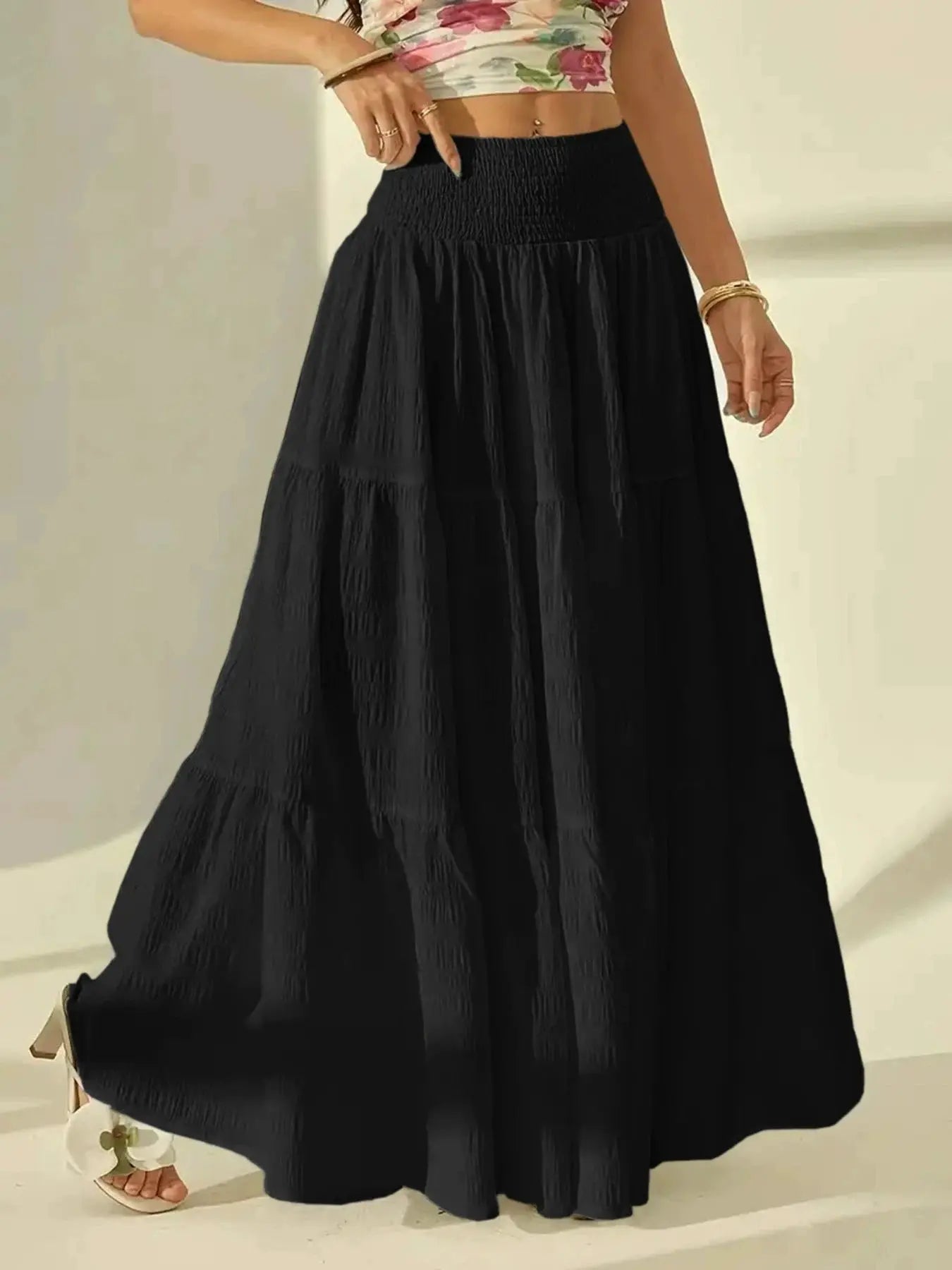 Black tiered maxi skirt from Simples Market with a high-waisted, smocked elastic waistband and pleated, flowy silhouette