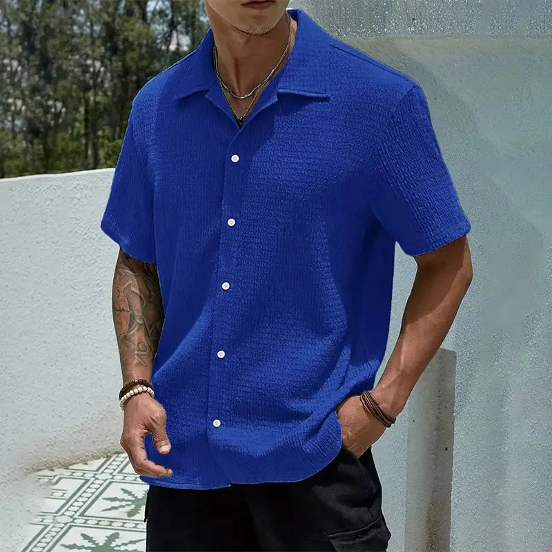 Men's short-sleeve casual shirt in bright blue with white buttons and textured fabric.