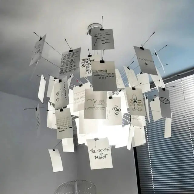 Ingo Maurer colored paper chandelier replica by Simples Market; white hanging paper cards around a modern ceiling light