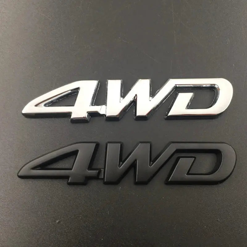 Two 3D metal 4WD car emblems in chrome and black finishes.