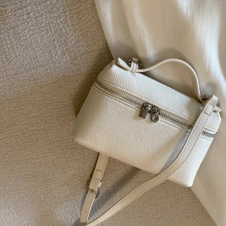 Mini white lychee-grain shoulder bag with top handle, detachable crossbody strap, and zippered front pocket