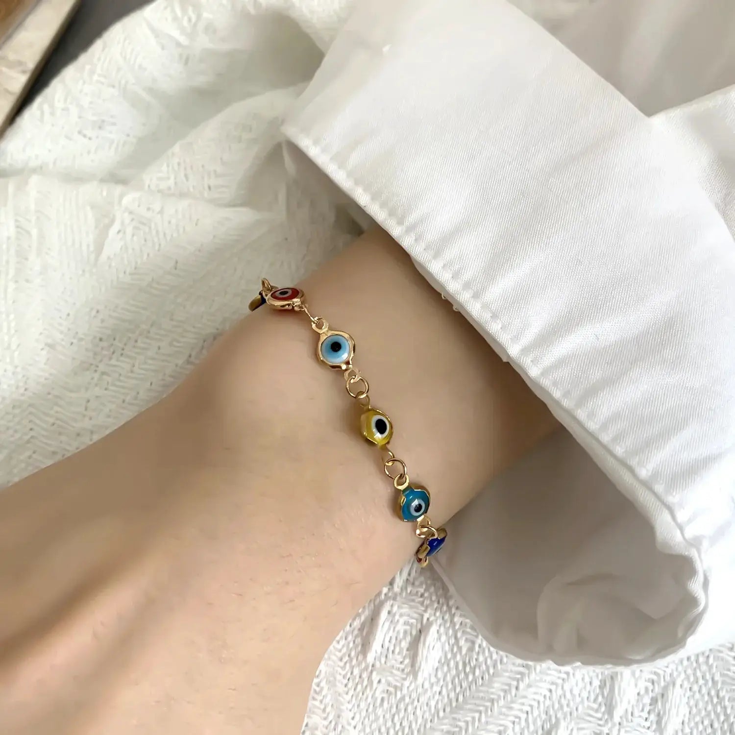 Lucky Turkey Evil Eye bracelet with colorful blue, red and yellow eye charms on a gold-tone adjustable chain.