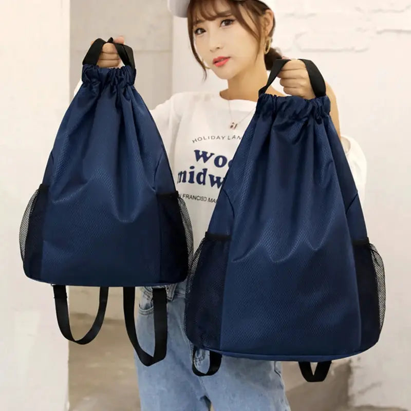 Two navy blue drawstring backpacks with mesh side pockets, large-capacity unisex bags for sports or travel.