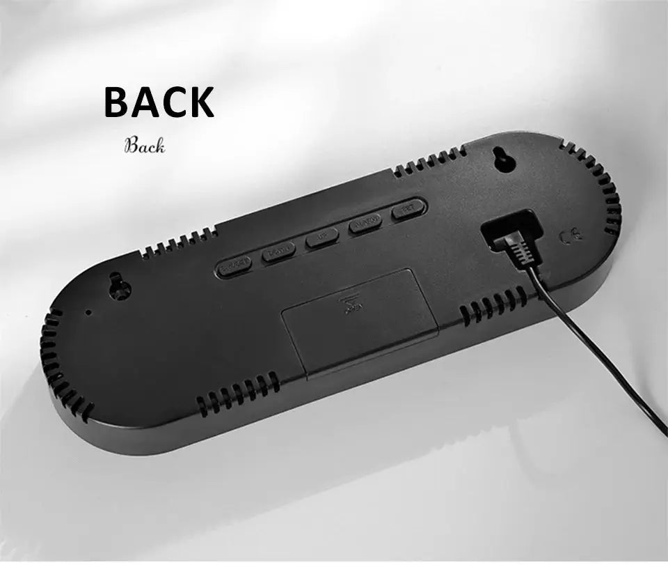 Digital LED wall clock viewed from the back; black plastic casing with control buttons and power cord.