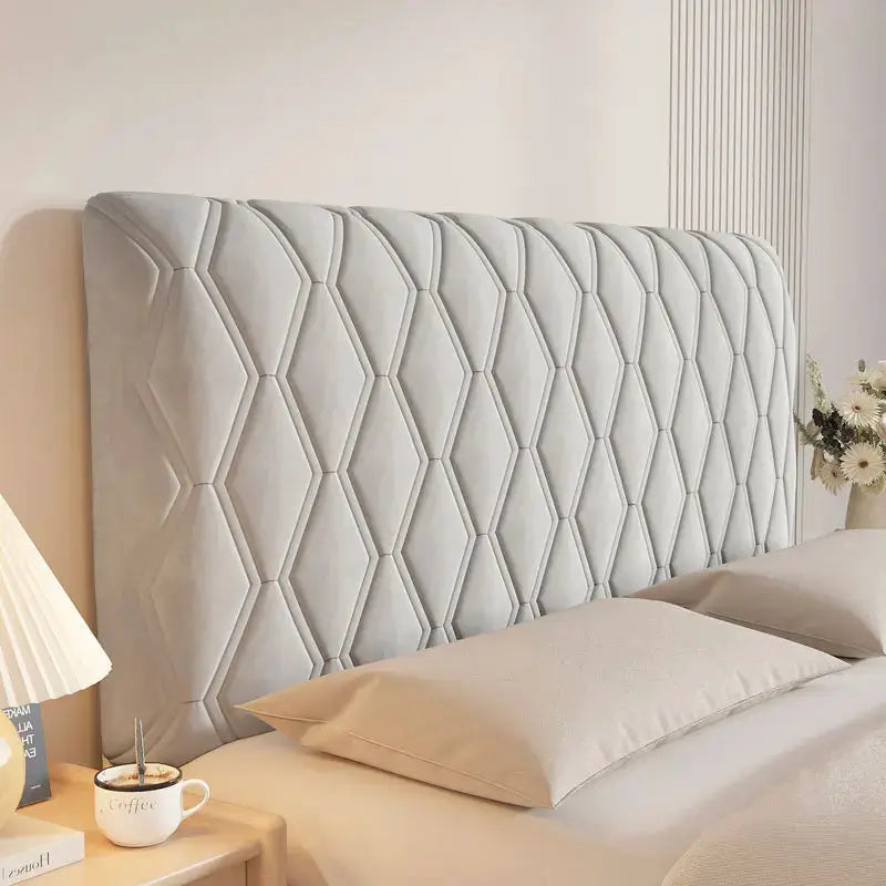 Headboard cover in light gray velvet with diamond-quilted pattern.