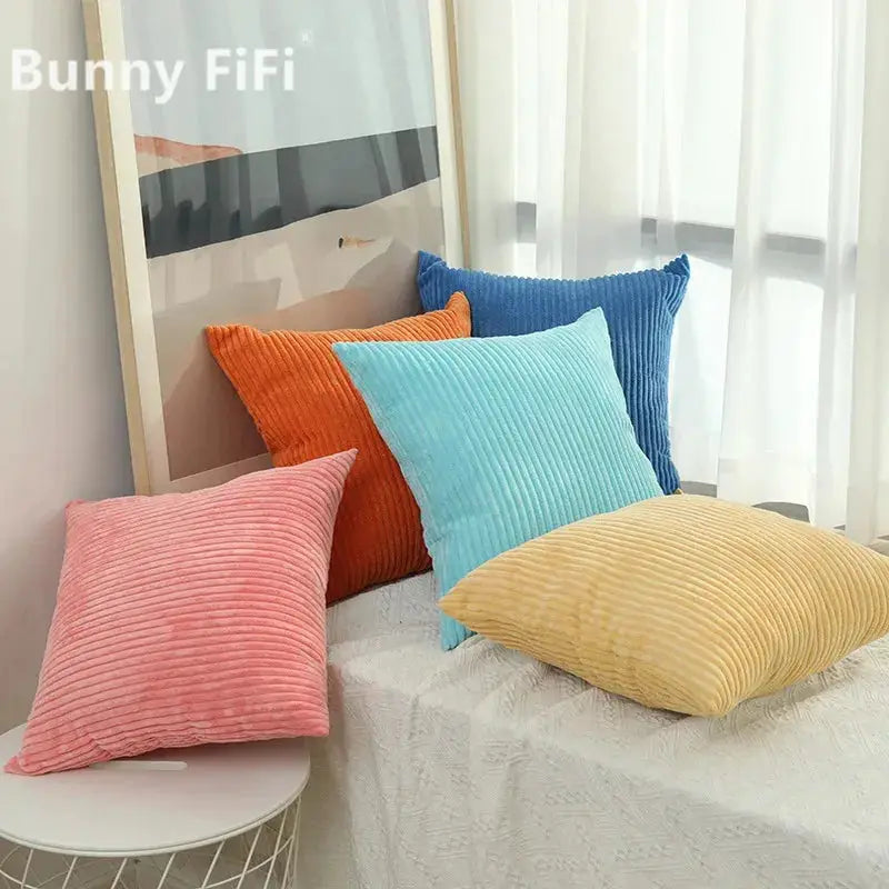 Corduroy striped cushion covers, set of six in pink, orange, light blue, teal, royal blue and yellow on a white bed