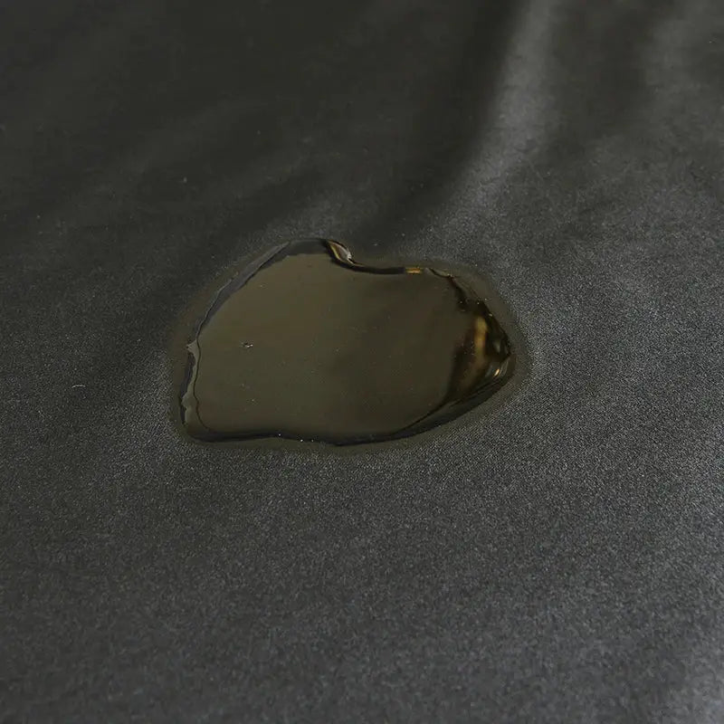 Waterproof fitted bed sheet in black with water beading on fabric surface