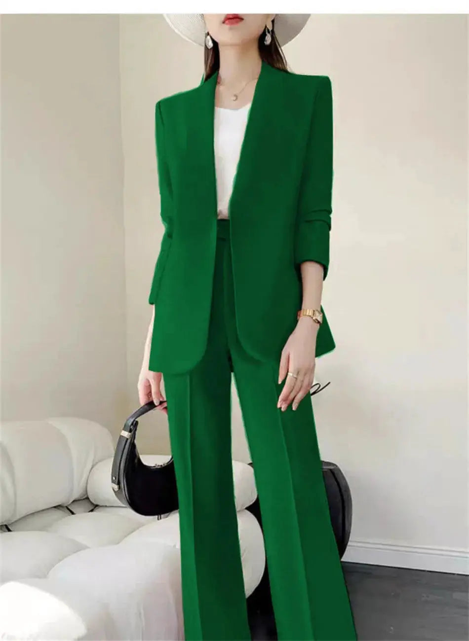 Green 2-piece women's pantsuit with blazer and wide-leg pants, white top, black handbag.