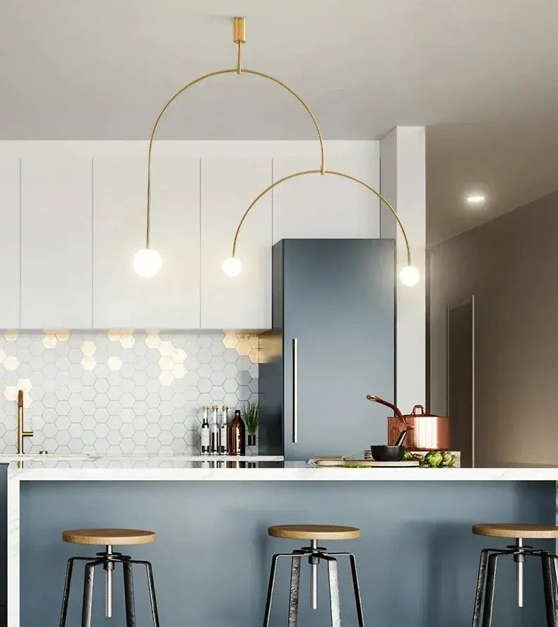 Nordic minimalist chandelier with gold geometric arches and three globe bulbs over kitchen island