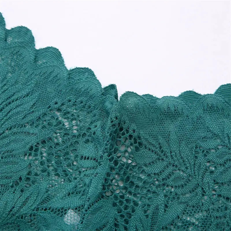 Lace floral teal underwear fabric close-up with hollow-out pattern