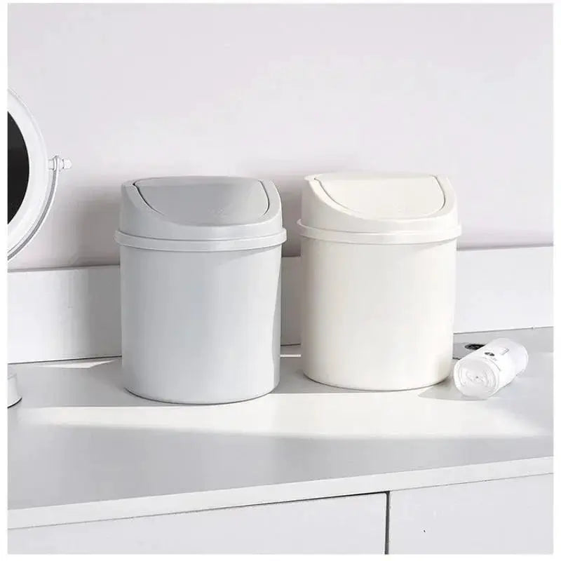 Simples Market mini desktop trash cans with lids; two cylindrical bins in light gray and cream on a white desk