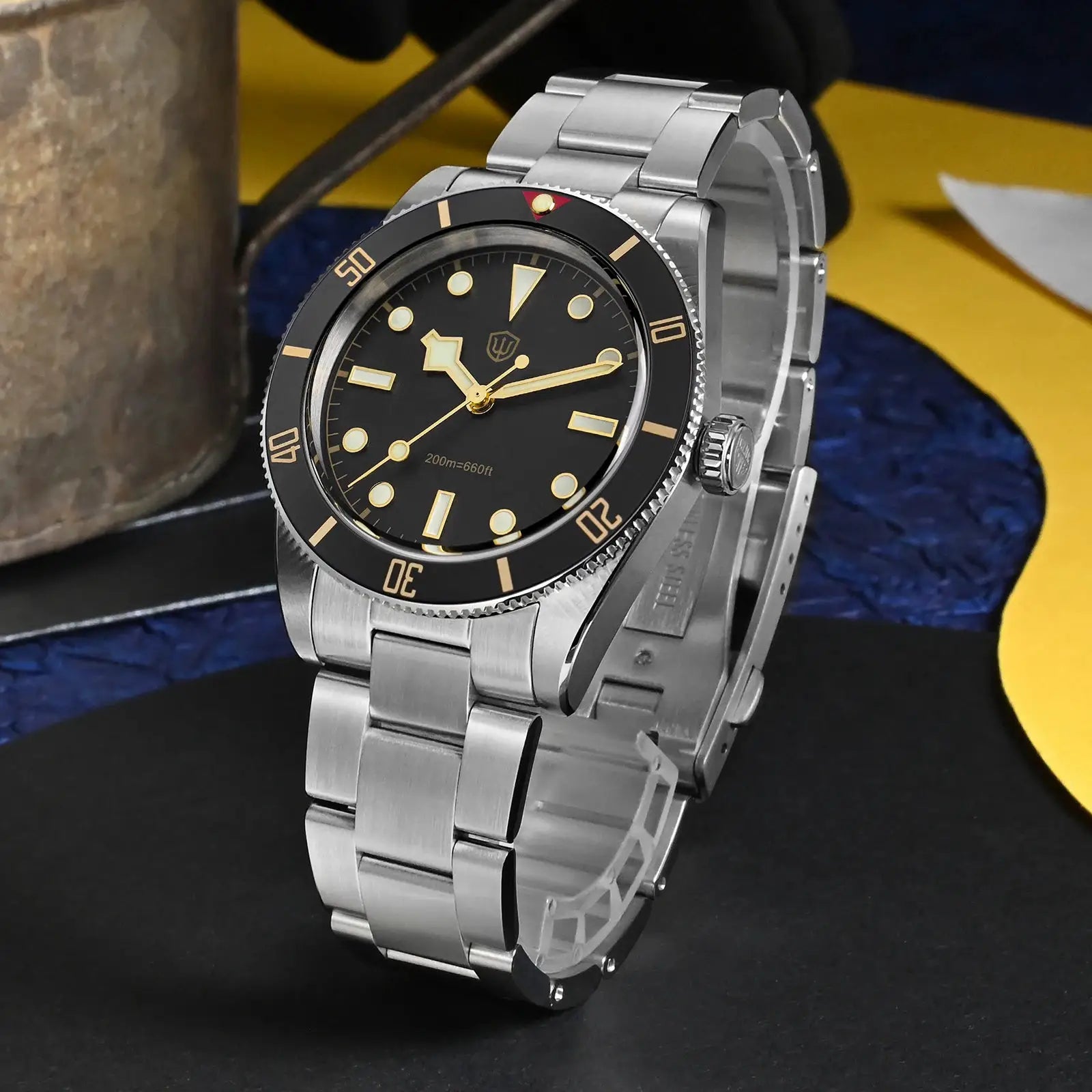 Diver watch with stainless steel bracelet, black dial, gold luminous markers and rotating bezel.