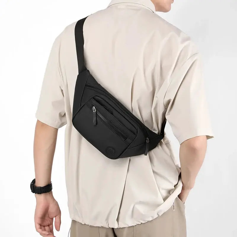 Unisex waterproof waist bag in black, worn crossbody as a belt pouch with zip pockets.