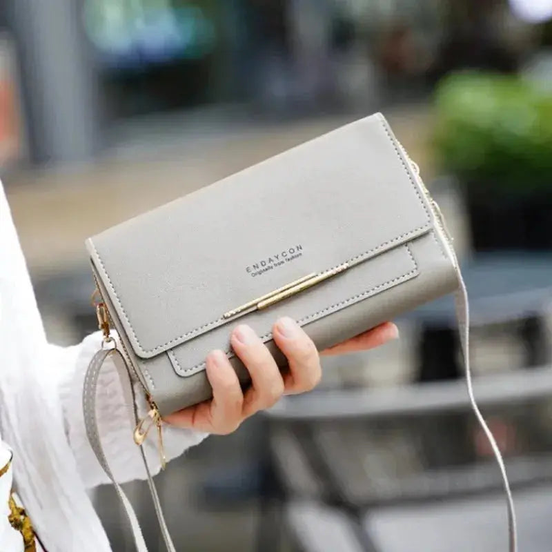 Women's gray mid-size wallet bag with convertible strap, coin pocket, gold-tone bar