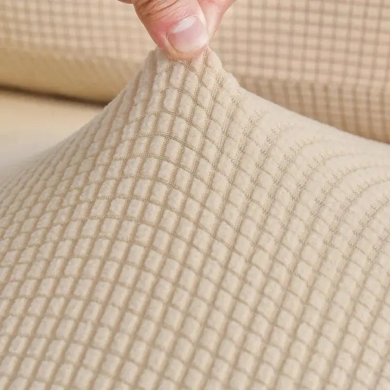 Elastic beige sofa cover with textured grid pattern