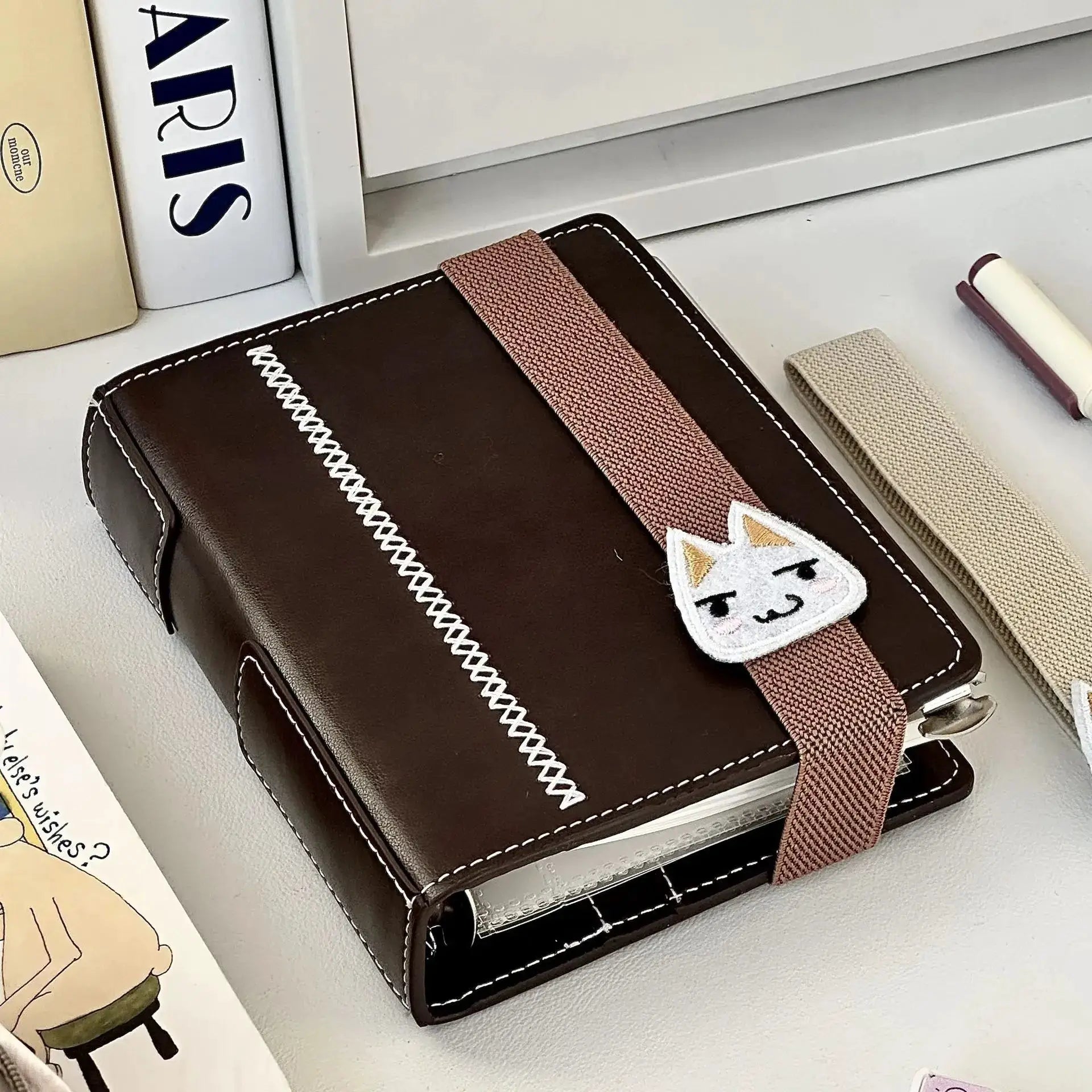 Dark brown faux-leather A7 planner with pink strap and detachable loose-leaf pages, 80 pages