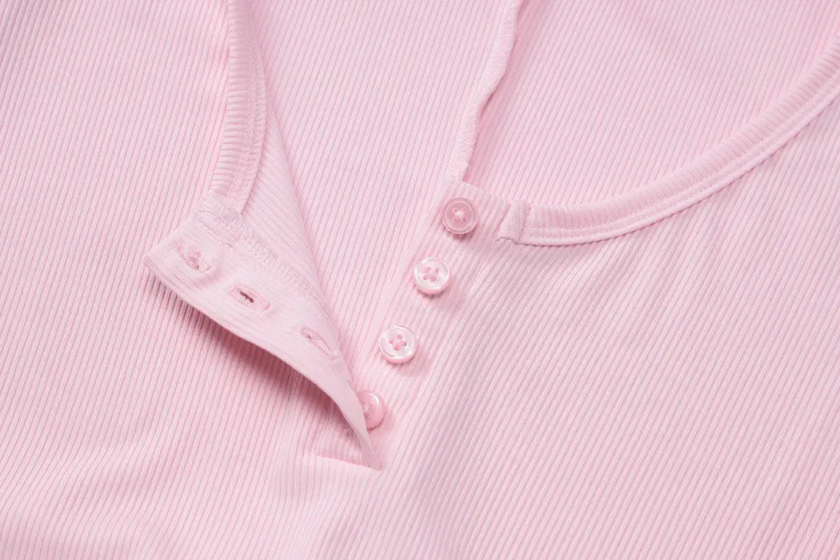 Pink ribbed playsuit close-up with square collar and pink button placket