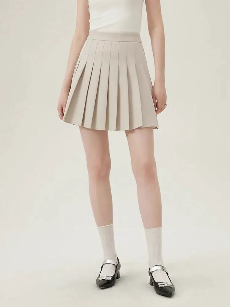 Women's beige pleated mini skirt; classic officewear look.