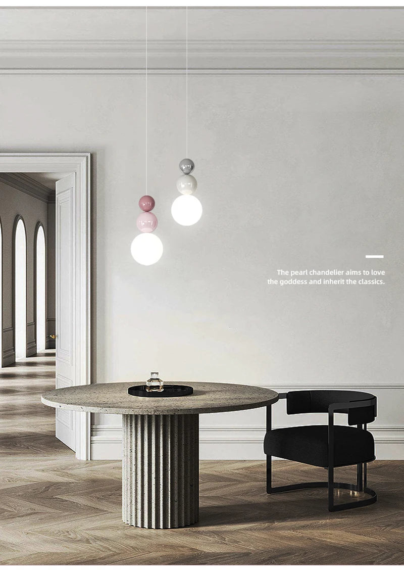 Nordic pendant light set: three modern LED hanging lamps with glass bead accents in pink and white over a round table.