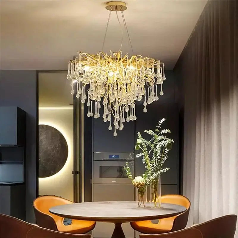 Royal Nordic luxury crystal chandelier by Simples Market in gold chrome with water drop crystals, over a dining table.